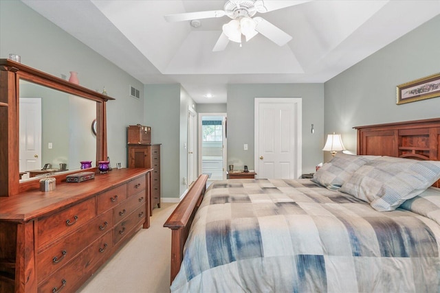 7520 Haflinger Cir, Kalamazoo, MI 49009 - bedroom featuring light carpet, a ceiling fan, a tray ceiling, and ensuite bathroom
