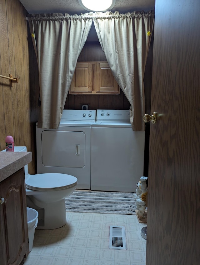 1310 Windridge Ln, Fremont, MI 49412 - full bathroom with independent washer and dryer, a tub, tile patterned floors, wooden walls, and vanity