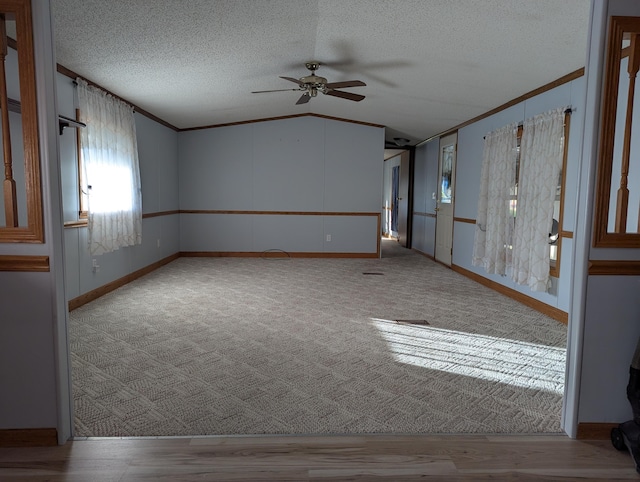 1310 Windridge Ln, Fremont, MI 49412 - spare room featuring a ceiling fan, lofted ceiling, ornamental molding, and a textured ceiling