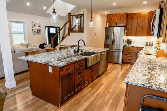 2634 Fitzgerald Ave, Fremont, MI 49412 - kitchen featuring stainless steel appliances, light wood-type flooring, light stone countertops, hanging light fixtures, and recessed lighting