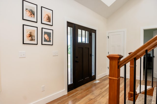 2634 Fitzgerald Ave, Fremont, MI 49412 - entryway with light wood-style floors, stairs, and vaulted ceiling