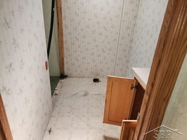2502 Lynnwood Ave, Saginaw, MI 48601 - bathroom with wallpapered walls and vanity