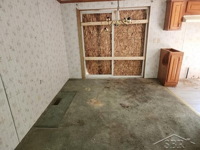 2502 Lynnwood Ave, Saginaw, MI 48601 - unfurnished living room with wallpapered walls, a chandelier, and carpet floors