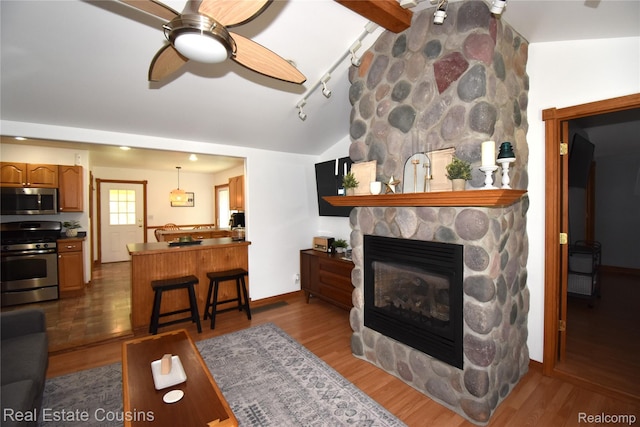 116 Park St, Gaines, MI 48436 - living room featuring lofted ceiling, ceiling fan, dark wood-style floors, and a fireplace