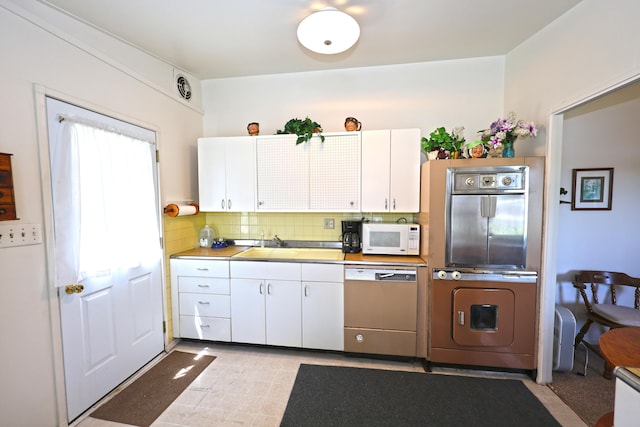31467 Maple Island Rd, Dowagiac, MI 49047 - kitchen with white appliances, white cabinetry, washer / dryer, and backsplash