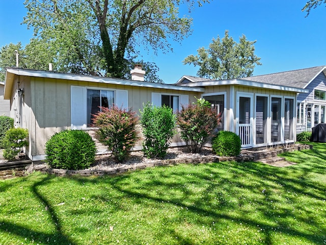 31467 Maple Island Rd, Dowagiac, MI 49047 - rear view of house with a lawn, a chimney, and a sunroom