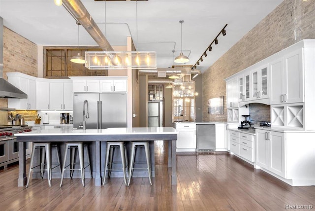 127 S Union St, Traverse City, MI 49684 - kitchen featuring high end appliances, a breakfast bar, light countertops, white cabinets, and a high ceiling