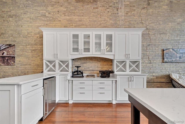 127 S Union St, Traverse City, MI 49684 - kitchen with beverage cooler, white cabinetry, glass insert cabinets, dark wood finished floors, and brick wall