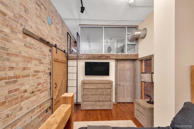 127 S Union St, Traverse City, MI 49684 - living area with wood finished floors, brick wall, a barn door, and a towering ceiling