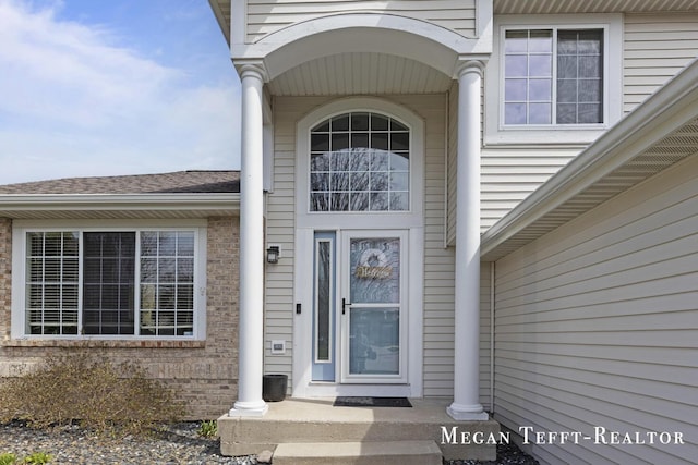 6641 Laguna Vista Dr NE, Rockford, MI 49341 - view of exterior entry featuring brick siding and a shingled roof