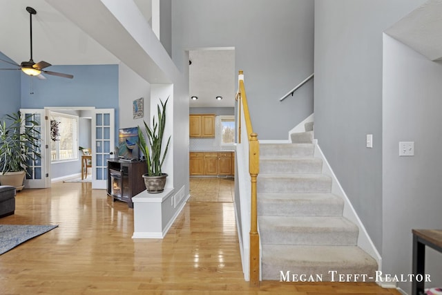 6641 Laguna Vista Dr NE, Rockford, MI 49341 - staircase featuring a high ceiling, ceiling fan, wood finished floors, and healthy amount of natural light