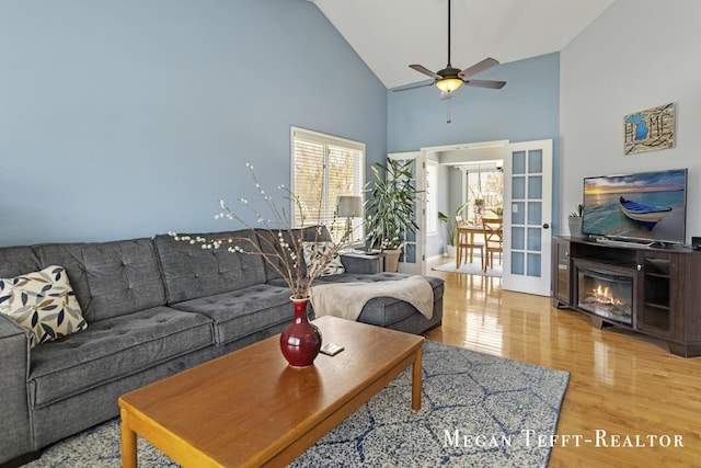 6641 Laguna Vista Dr NE, Rockford, MI 49341 - living area with high vaulted ceiling, light wood-style floors, ceiling fan, and a glass covered fireplace