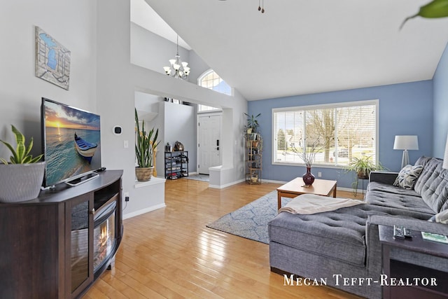 6641 Laguna Vista Dr NE, Rockford, MI 49341 - living area with a chandelier, light wood finished floors, and high vaulted ceiling