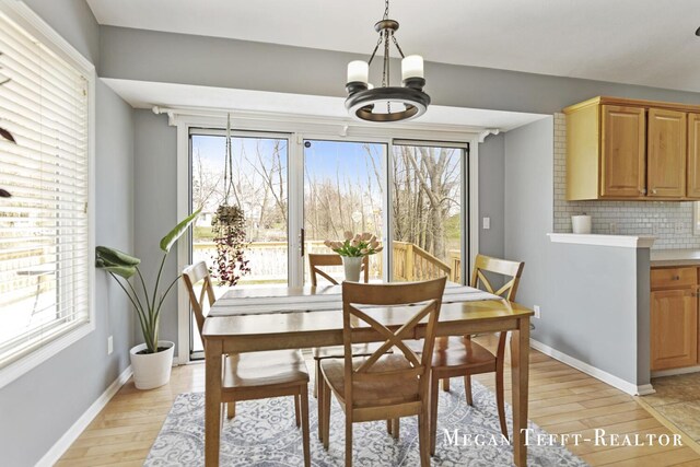 6641 Laguna Vista Dr NE, Rockford, MI 49341 - dining area with light wood-type flooring and a chandelier