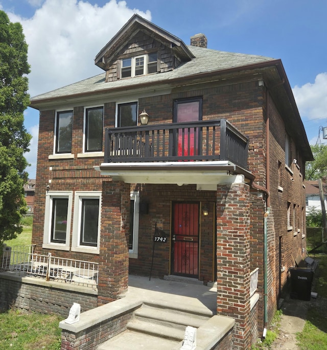 3742 W Grand St, Detroit, MI 48238 - view of front of home with a balcony, brick siding, a chimney, and covered porch