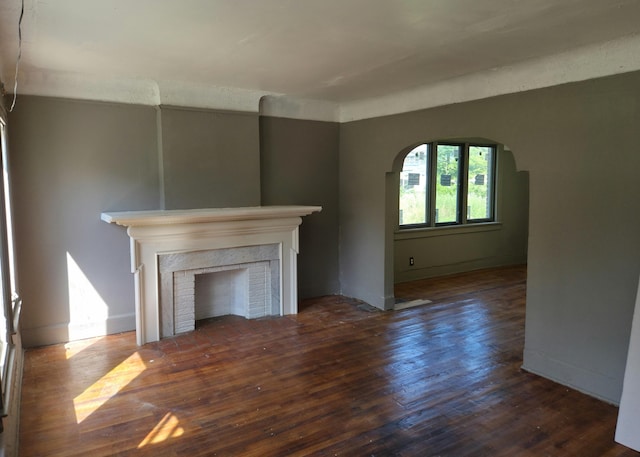 3742 W Grand St, Detroit, MI 48238 - unfurnished living room with arched walkways, a fireplace, and hardwood / wood-style flooring