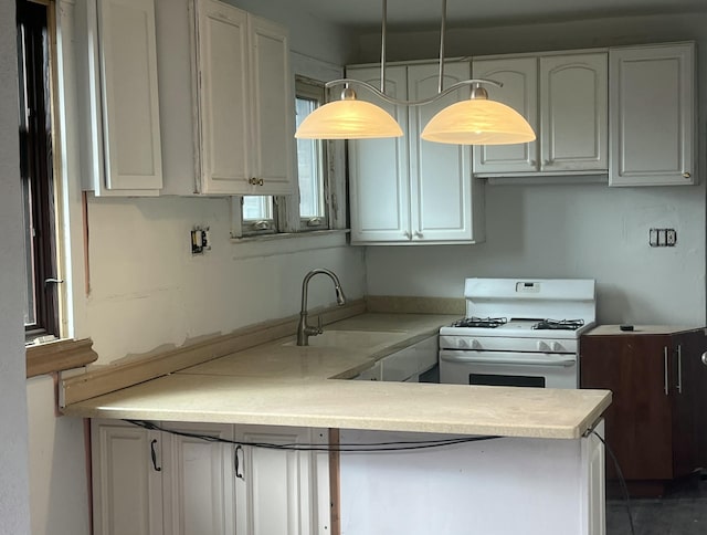 3742 W Grand St, Detroit, MI 48238 - kitchen with white gas range oven, a peninsula, light countertops, and white cabinetry