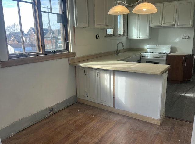 3742 W Grand St, Detroit, MI 48238 - kitchen featuring white gas stove, wood finished floors, a peninsula, light countertops, and white cabinets