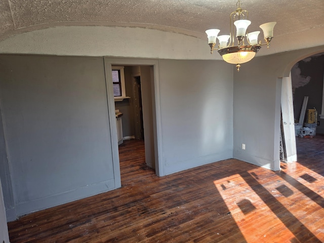 3742 W Grand St, Detroit, MI 48238 - empty room featuring arched walkways, hardwood / wood-style floors, and a chandelier