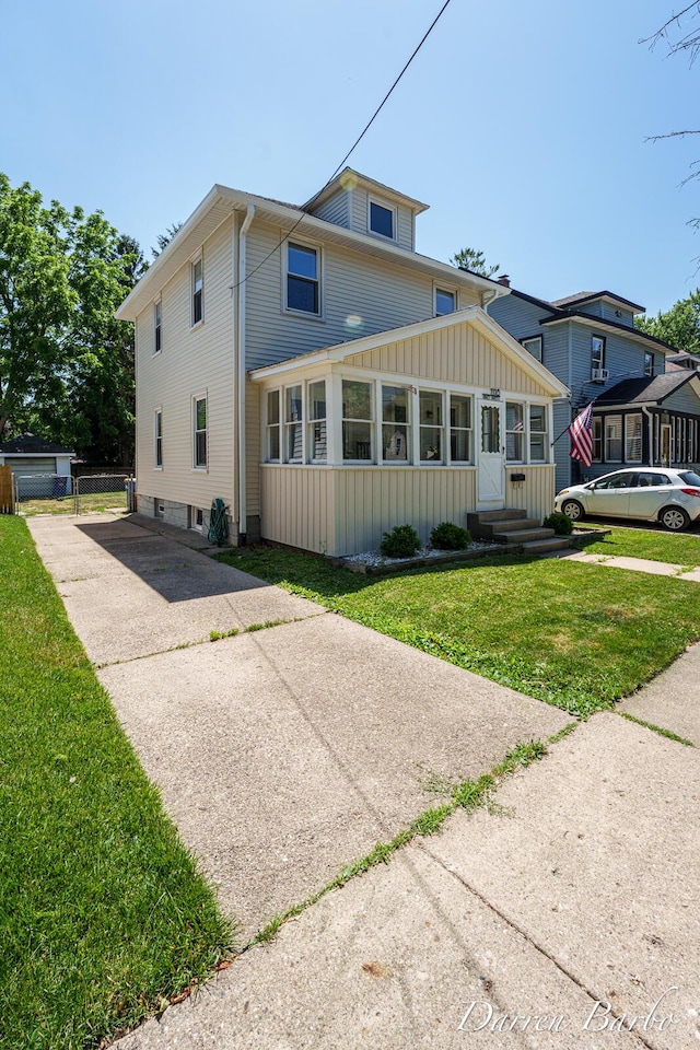 1118 Sibley St NW, Grand Rapids, MI 49504 - view of front of property featuring board and batten siding, entry steps, a front lawn, and concrete driveway