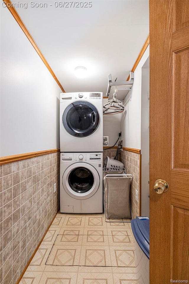 15375 Murray Rd, Byron, MI 48418 - laundry area featuring tile walls, stacked washing machine and dryer, and a wainscoted wall