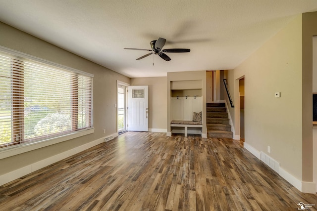 7558 Indian Rd, Temperance, MI 48182 - unfurnished living room featuring wood finished floors, ceiling fan, and stairway
