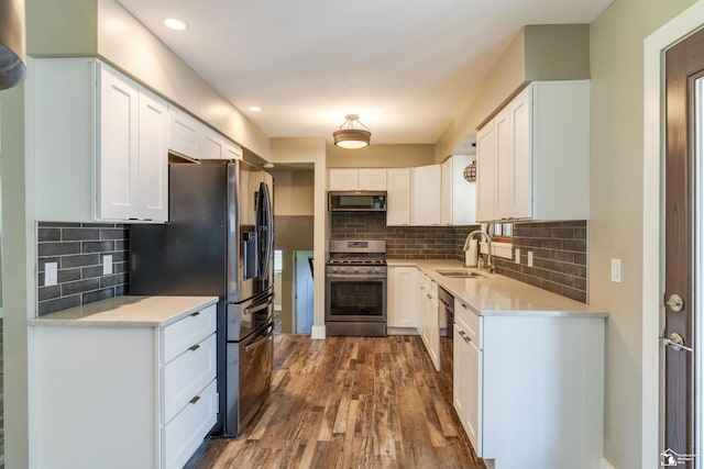 7558 Indian Rd, Temperance, MI 48182 - kitchen with appliances with stainless steel finishes, dark wood-type flooring, white cabinets, decorative backsplash, and recessed lighting