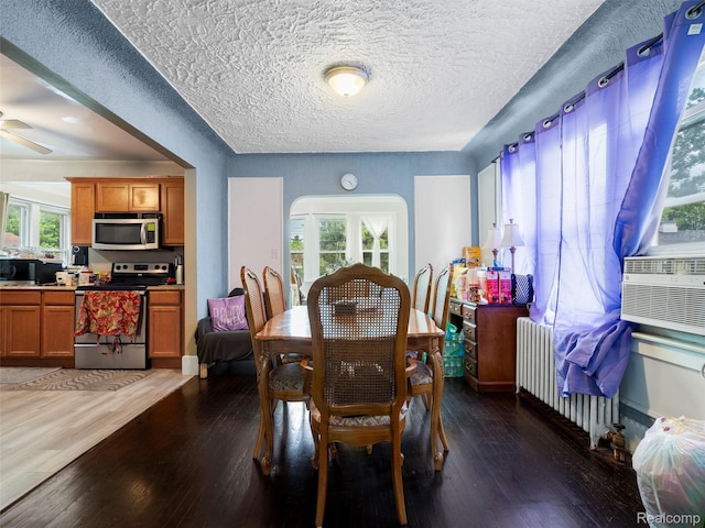 7420 Coolidge, Center Line, MI 48015 - dining area featuring radiator heating unit, wood finished floors, ceiling fan, arched walkways, and a textured ceiling