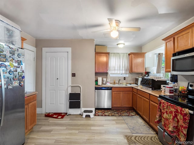 7420 Coolidge, Center Line, MI 48015 - kitchen with appliances with stainless steel finishes, a ceiling fan, light countertops, light wood-style flooring, and brown cabinets