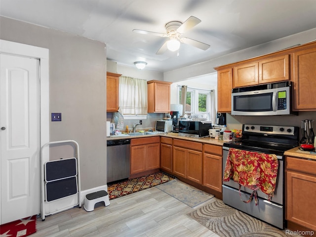 7420 Coolidge, Center Line, MI 48015 - kitchen featuring appliances with stainless steel finishes, ceiling fan, light countertops, light wood-style flooring, and brown cabinets