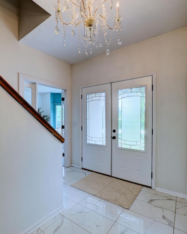 10895 Riley St, Zeeland, MI 49464 - entryway with a chandelier, french doors, and marble finish flooring