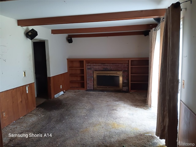 3375 Jacque St, Flint, MI 48532 - unfurnished living room with wainscoting, wooden walls, a fireplace, beam ceiling, and carpet floors