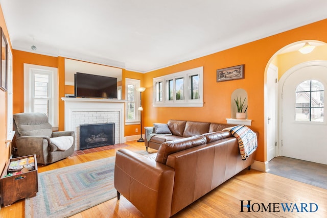 660 Deming St SE, Grand Rapids, MI 49507 - living area with a brick fireplace, wood finished floors, and arched walkways