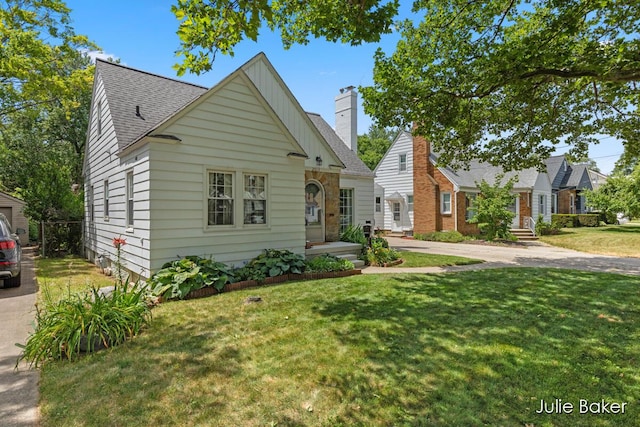 2013 Duiker Ave NE, Grand Rapids, MI 49505 - bungalow-style home featuring a front lawn, a shingled roof, and driveway