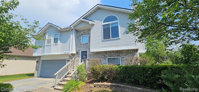 38478 Draper Ln, Westland, MI 48186 - split foyer home with concrete driveway, a garage, a chimney, and brick siding