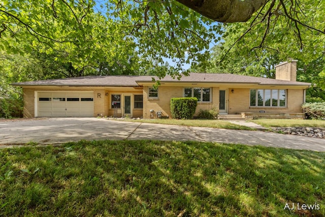 2155 Lake Michigan Dr NW, Grand Rapids, MI 49504 - ranch-style home with a chimney, a garage, concrete driveway, a front lawn, and brick siding
