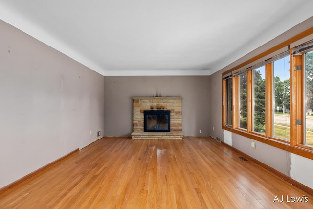 2155 Lake Michigan Dr NW, Grand Rapids, MI 49504 - unfurnished living room with light wood-style flooring and a stone fireplace