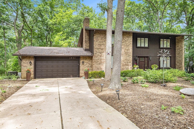 3924 Penberton Dr, Ann Arbor, MI 48105 - view of front of home with an attached garage, a chimney, brick siding, and concrete driveway