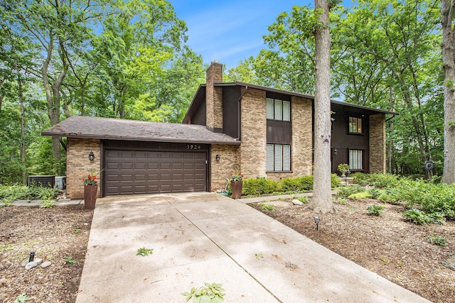 3924 Penberton Dr, Ann Arbor, MI 48105 - view of front facade featuring a chimney, a garage, concrete driveway, and brick siding
