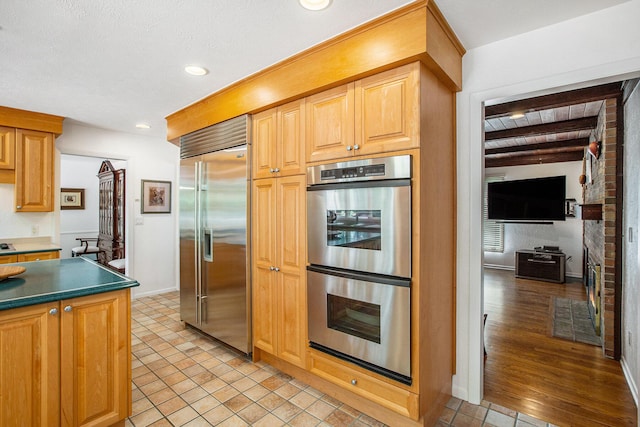 3924 Penberton Dr, Ann Arbor, MI 48105 - kitchen featuring appliances with stainless steel finishes, dark countertops, recessed lighting, and beamed ceiling