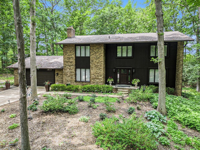 3924 Penberton Dr, Ann Arbor, MI 48105 - view of front of property featuring a chimney, an attached garage, concrete driveway, and roof with shingles
