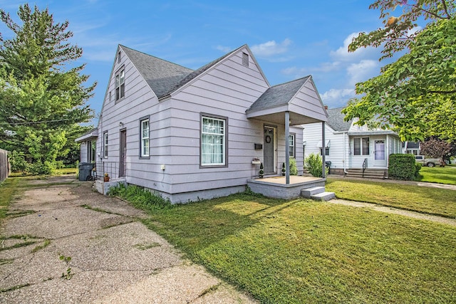 1209 Mohawk Ln, Saint Joseph, MI 49085 - bungalow-style house with roof with shingles, a front lawn, and concrete driveway