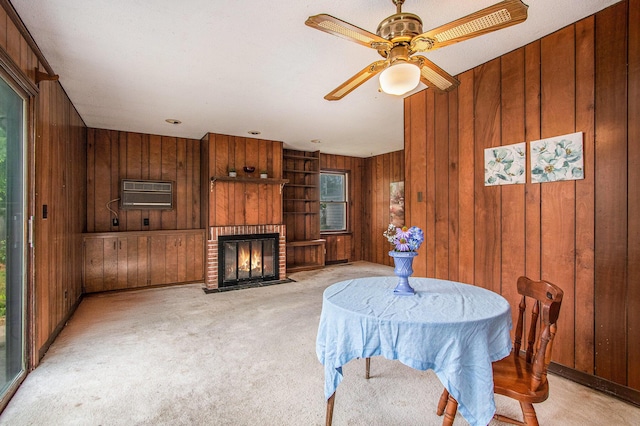 1209 Mohawk Ln, Saint Joseph, MI 49085 - dining room with wooden walls, a wall mounted air conditioner, light colored carpet, a fireplace, and ceiling fan
