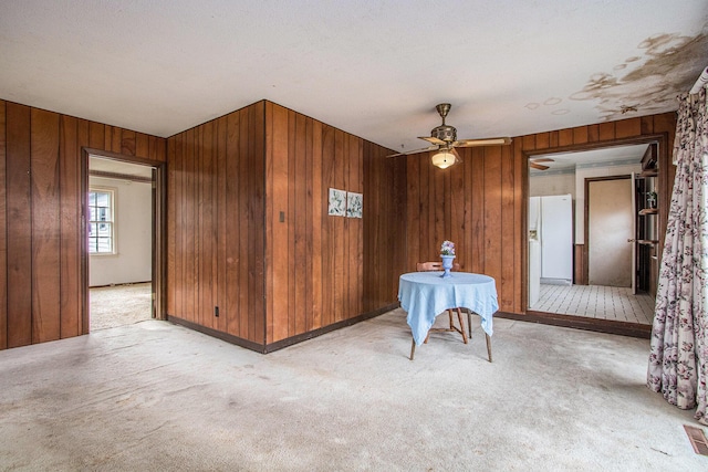 1209 Mohawk Ln, Saint Joseph, MI 49085 - unfurnished dining area with wooden walls, light colored carpet, and a ceiling fan