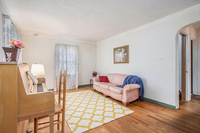 1209 Mohawk Ln, Saint Joseph, MI 49085 - living room with arched walkways, a textured ceiling, wood finished floors, and crown molding