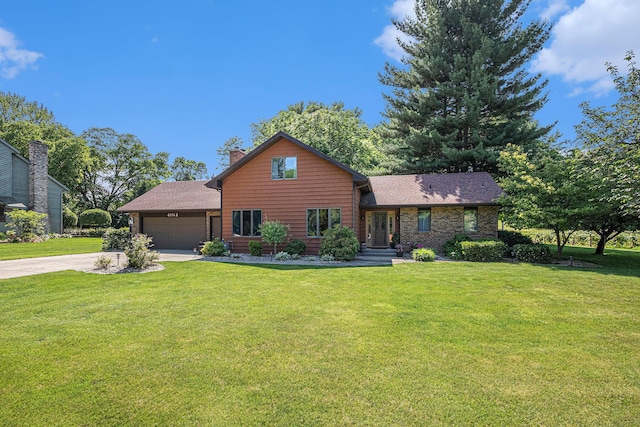 4102 Tomahawk Way, Saint Joseph, MI 49085 - view of front of home with concrete driveway, an attached garage, a front lawn, a chimney, and a shingled roof