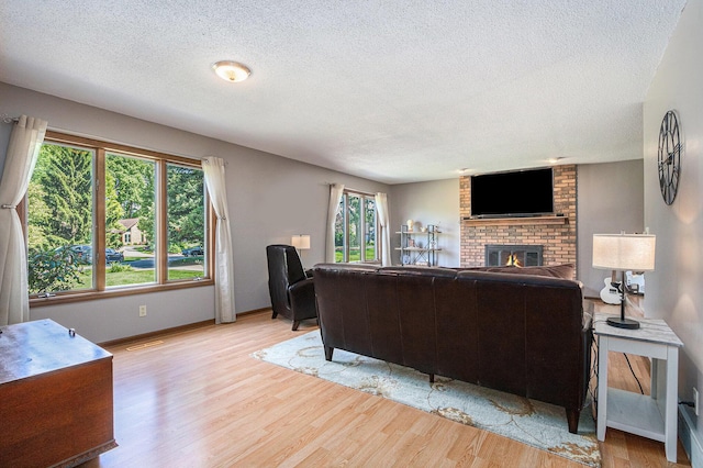 4102 Tomahawk Way, Saint Joseph, MI 49085 - living room with a textured ceiling, light wood-style floors, and a brick fireplace