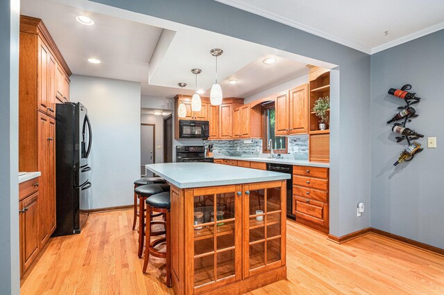 4102 Tomahawk Way, Saint Joseph, MI 49085 - kitchen with black appliances, light countertops, light wood-style flooring, backsplash, and ornamental molding