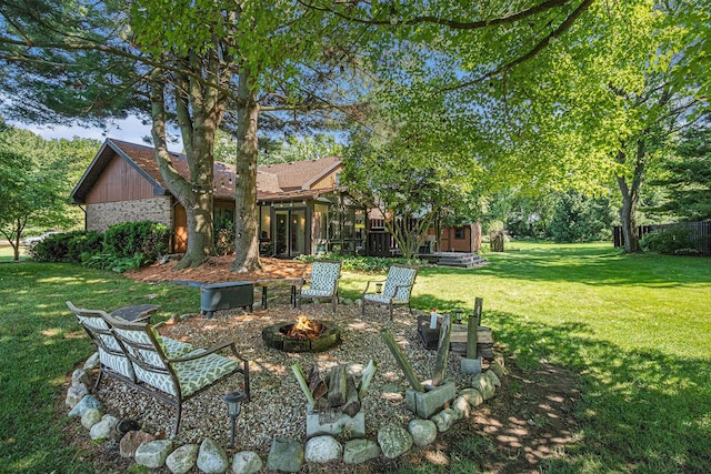 4102 Tomahawk Way, Saint Joseph, MI 49085 - view of grassy yard with a fire pit and a sunroom
