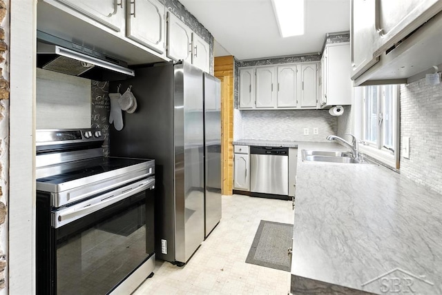534 S Main St, Au Gres, MI 48703 - kitchen with stainless steel appliances, under cabinet range hood, light flooring, tasteful backsplash, and light countertops
